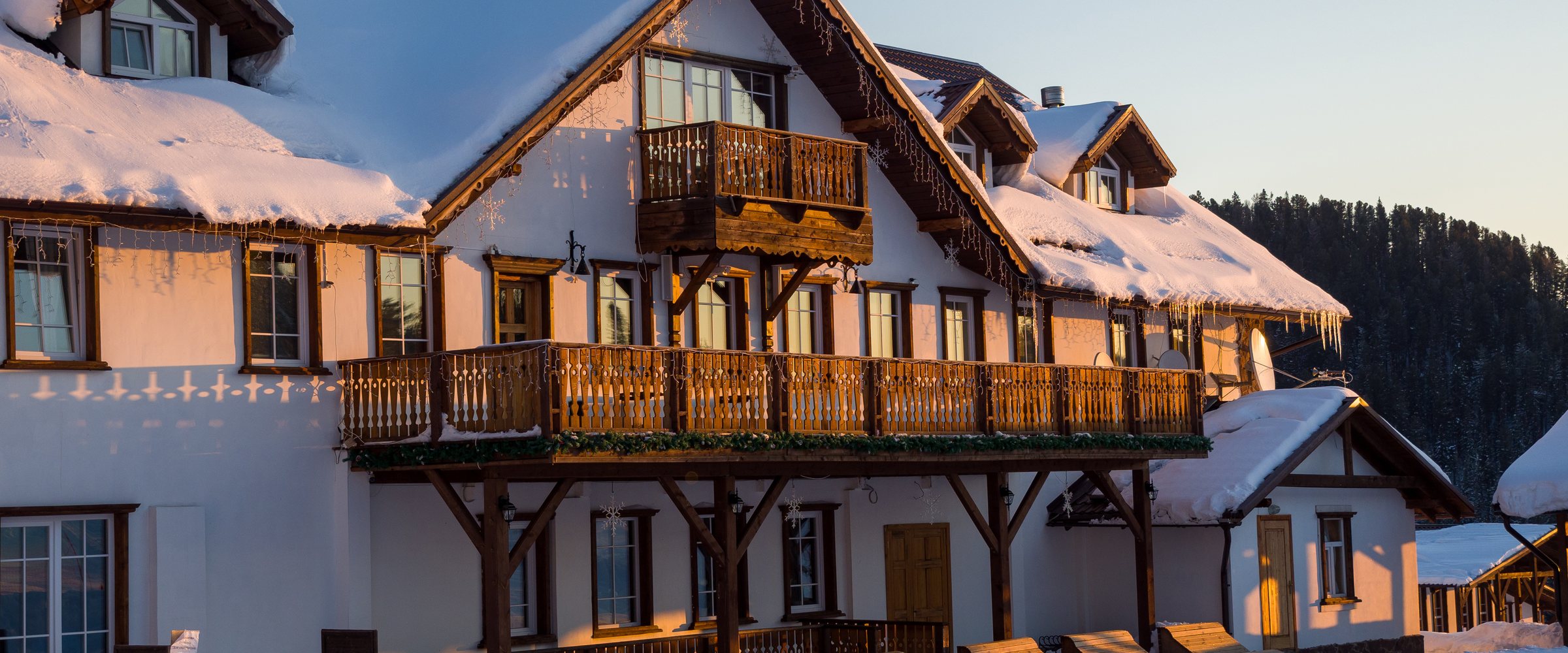 Alpine-style hotel house in the Gornaya Salanga ski resort. The sun rises. Beautiful morning lighting