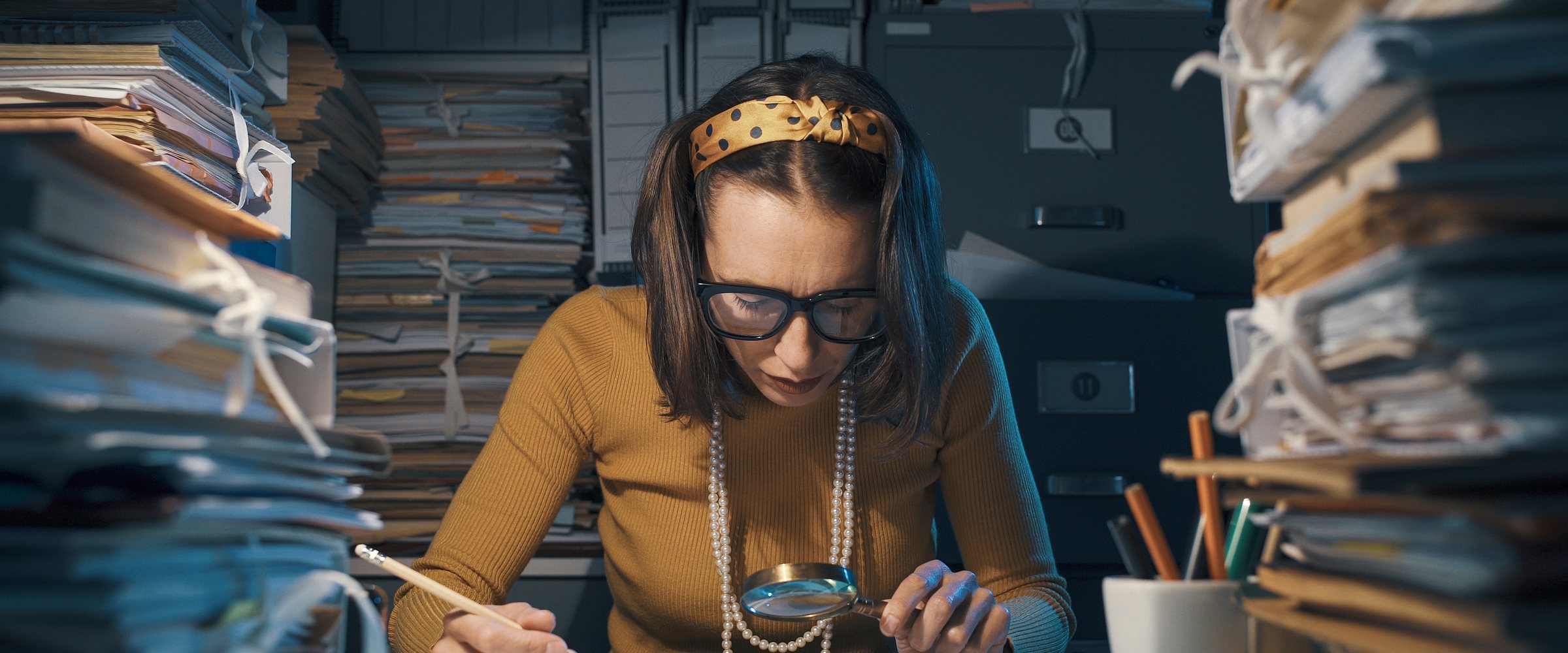 Businesswoman checking a contract with a magnifier