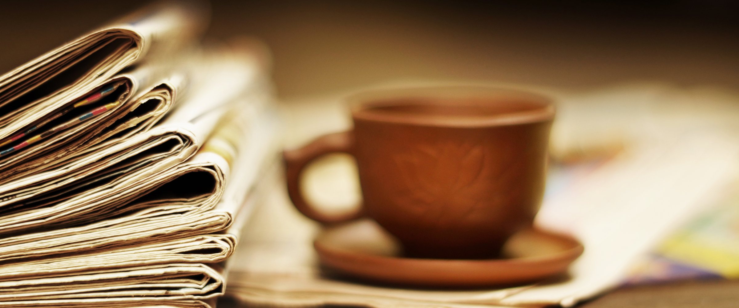 Newspapers and cup of coffee. Pile of folded papers with news and ceramic mug with drink. Heap of journal to be read at breakfast, concept for business morning.