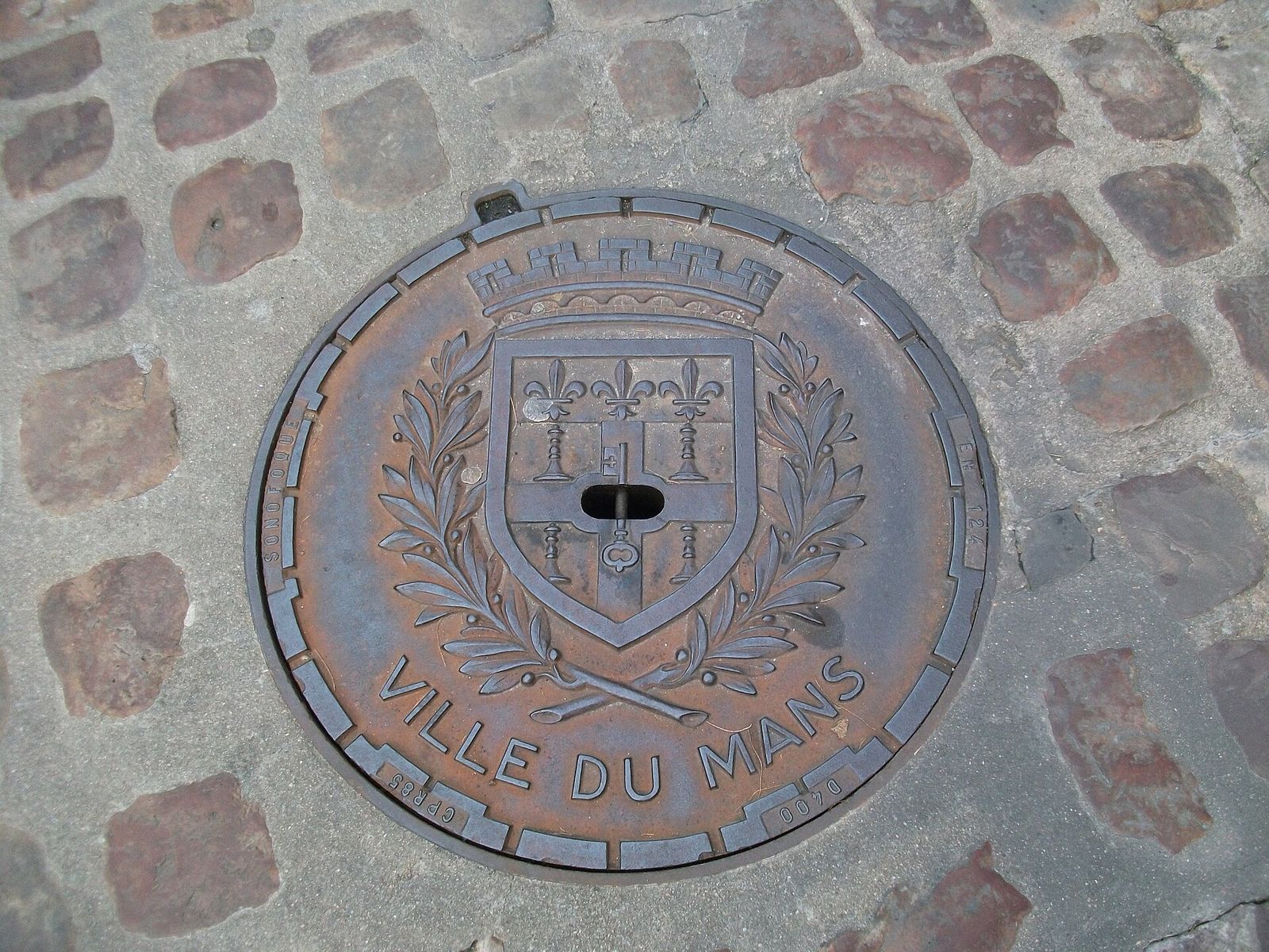 Manhole cover displaying the coat-of-arms of Le Mans